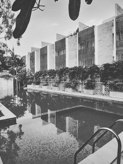 A black and white perspective of the ELEVANA row houses bordering the pool. This view highlights the architectural rhythm and form of the compact housing units.