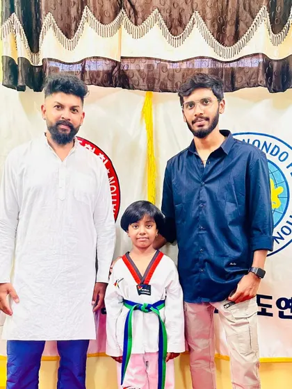 A young girl with her new green and blue belt.