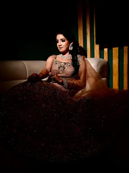 Another angle of this stunning Mehendi bride, showcasing the full grandeur of her attire. The deep shadows and focused light create a portrait that feels both classic and powerful.