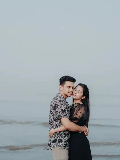 A gentle and romantic embrace by the sea, capturing a quiet moment of connection.