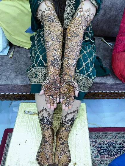 A full view of the bridal henna for Saima, showing the coordinated designs on her hands, arms, and feet.