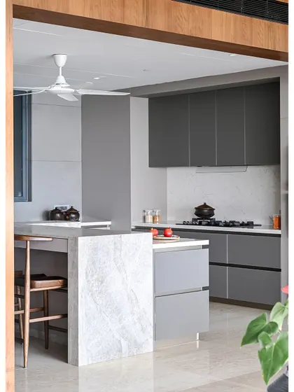 The open kitchen is designed to be a social hub. A large island with a quartzite countertop provides space for cooking preparation and casual dining.
