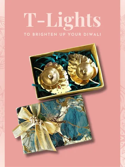 A set of two golden leaf-shaped T-light holders in a gift box. The delicate design is perfect for adding a touch of nature-inspired elegance to your decor.