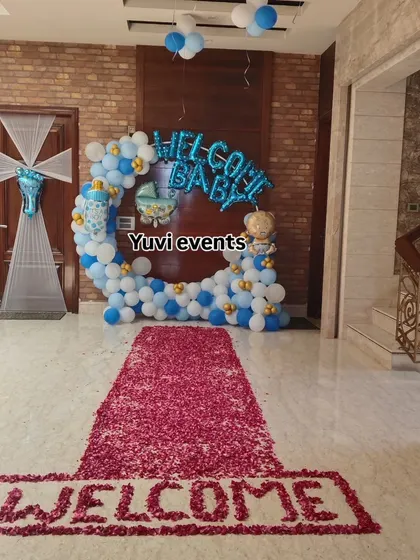 A grand 'Welcome Baby' entrance decoration. I used a blue and white balloon ring and a rose petal carpet to create a special welcome for the new baby and mother.