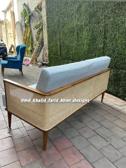 The back of the sofa, highlighting the full-length cane panel that gives it a light, airy feel.