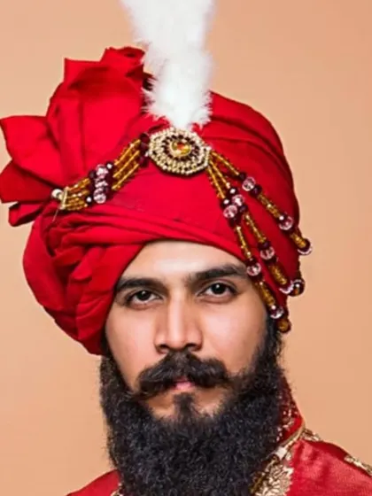 Another view of this majestic red safa, adorned with a 'kalgi' and beaded details. I pay close attention to the folds and shape to ensure the turban is a centerpiece of the groom's attire.