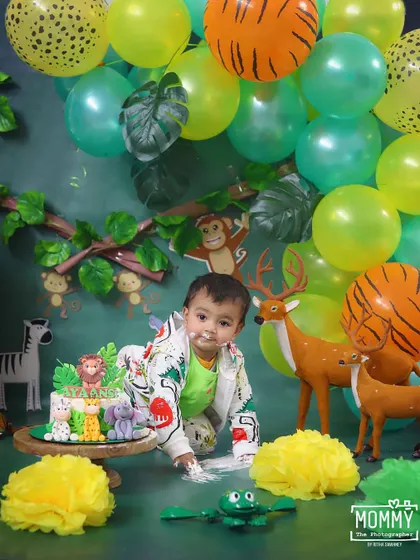 Welcome to the jungle! This little one is crawling towards his amazing animal-themed cake, ready for a wild time.