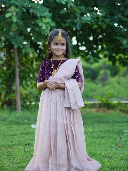 A beautiful blend of textures and colors. This custom half-saree look features a rich purple velvet blouse paired with a light, airy pink skirt and dupatta, creating a modern yet traditional outfit.