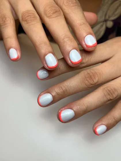 Sometimes simple is best. This clean look features a milky white base with a fine, bright orange micro-French tip for a subtle pop of color.