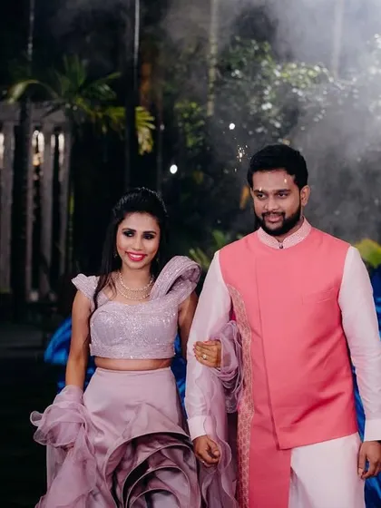 A dramatic entrance for the sangeet. The couple's modern, coordinated outfits look fantastic against the evening lights.