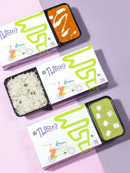 A clean and graphic flatlay of a tiffin delivery service's packaging. This top down shot highlights the convenient, modular design of the meal boxes, appealing to customers looking for organized meal solutions.