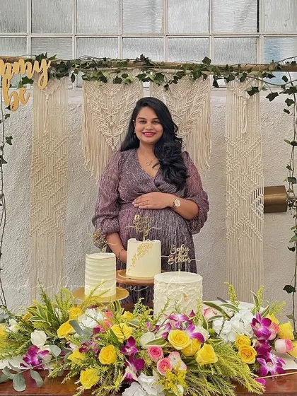 The beautiful mommy-to-be enjoying her surprise baby shower. The natural textures of the macrame and bamboo frame, combined with fresh greenery and flowers, created a warm and stylish photo corner.