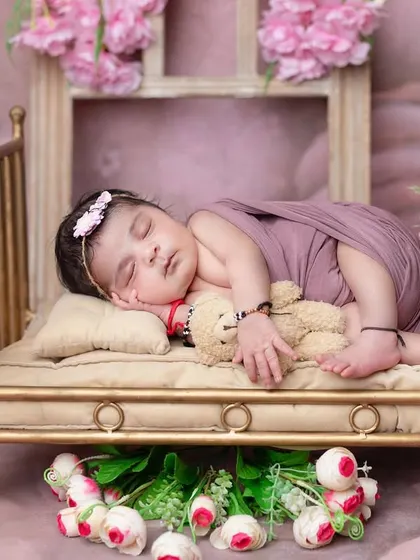 A beautiful side-sleeper pose on a miniature golden bed, surrounded by flowers.
