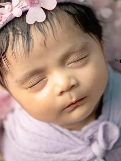 An intimate macro shot of a newborn's face, highlighting the soft skin and tiny features that change so quickly. These are the details you'll want to cherish.