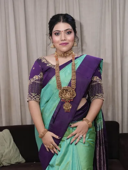 A full-length view of this elegant South Indian style. The soft makeup look perfectly balances the rich colors of the saree and the ornate temple jewelry.