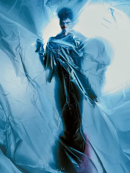 A ghostly silhouette created by backlighting the model through a sheet of plastic. The image is abstract and focuses on form and light rather than a clear portrait.