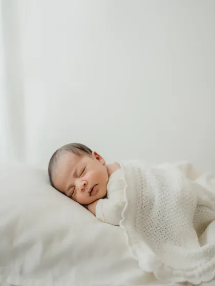 The soft light and white-on-white styling create a truly angelic feel for this sleeping newborn portrait.