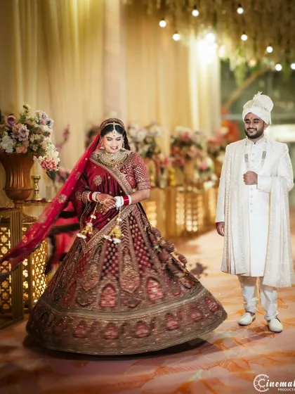 A stunning portrait of the bride twirling in her magnificent lehenga, with her groom looking on. This shot captures the beauty and movement of her attire.