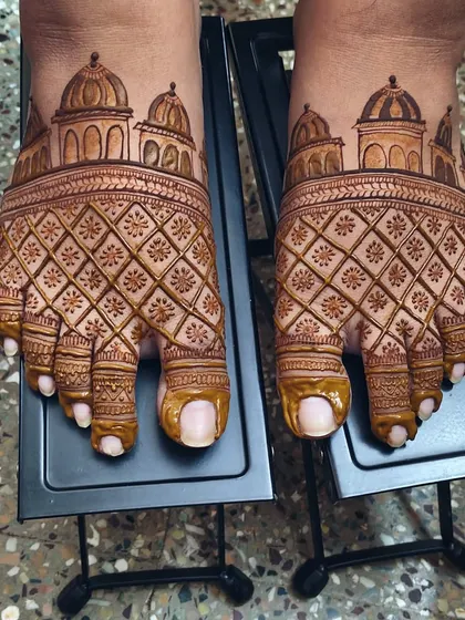 An architectural-themed design for the feet, featuring domes and intricate jaali (net) patterns. This is a bold and unique choice for a bride who wants her foot mehndi to be a statement piece.