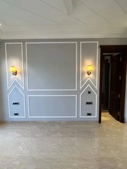 This bedroom at C-257 features beautiful marble flooring and a stylish grey accent wall with classic moulding and modern sconces. It’s a perfect blend of classic and contemporary design.