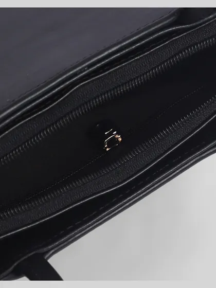 A macro shot of the inside of a black purse, focusing on the zipper and quality of the lining.