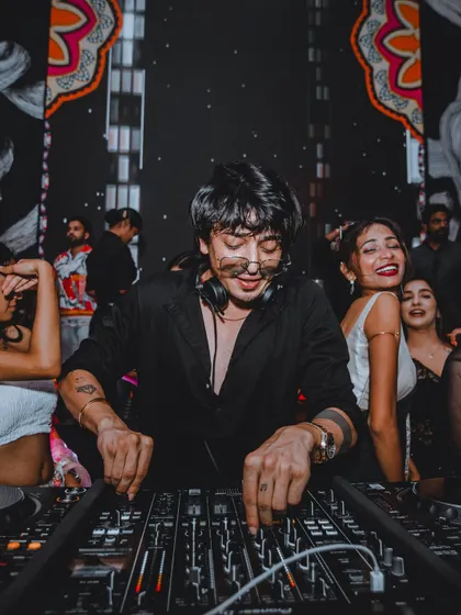 A photo of me smiling while mixing at a show. It shows the genuine joy and passion I have for my craft and for entertaining the crowd.
