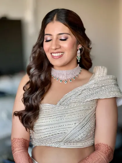 A joyful smile from this beautiful client, ready for her sangeet. The makeup features shimmery eyes and a subtle base, letting her happiness be the main focus.