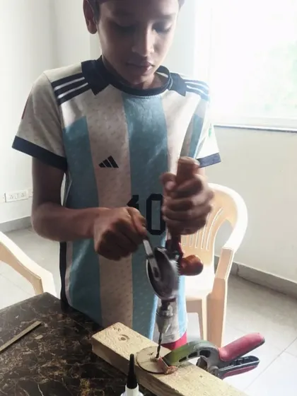 A student carefully operates a hand drill, demonstrating the focus and control we teach in our tool handling sessions.
