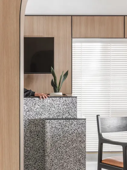 A detail of the monolithic quartz reception desk. The material's texture adds visual interest, while the tiered design provides functional surfaces for both staff and patients.