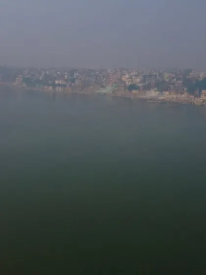 The vast, calm expanse of the Ganga river in the winter morning fog. There's a deep sense of spirituality and timelessness in this view.