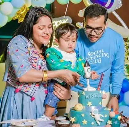 The family gathers around a space-themed cake for the cake-cutting ceremony, a key moment in any birthday party.