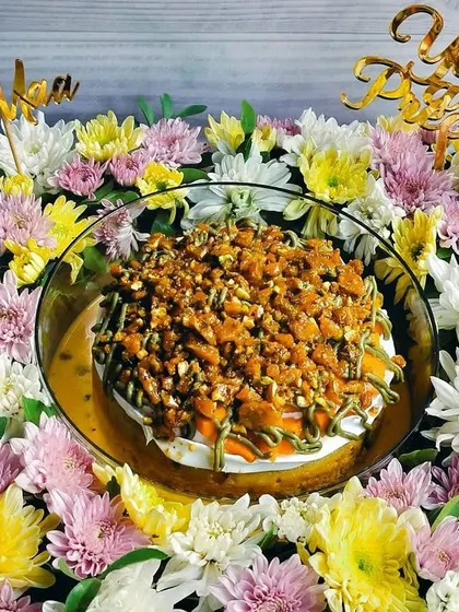 Another angle of the grand Mother's Day mango pistachio tres leches hamper, emphasizing the lushness of the surrounding flowers and the rich topping of the cake.