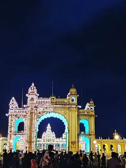 The Mysore Palace illuminated with brilliant blue and gold lights at night, a testament to the city's royal heritage. Capturing such landmarks is a passion of mine.