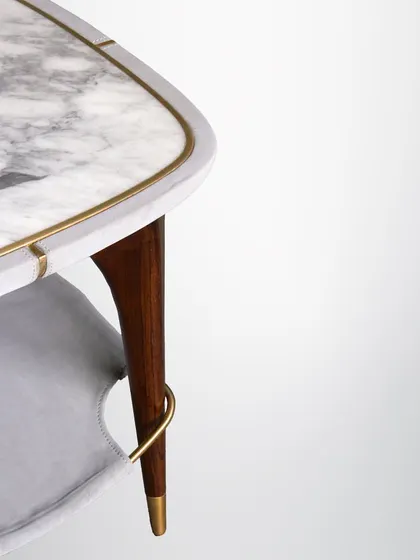 This versatile side table features a marble top with a brass inlay and a unique leather sling shelf for magazines or books. It's a perfect example of floating elegance.