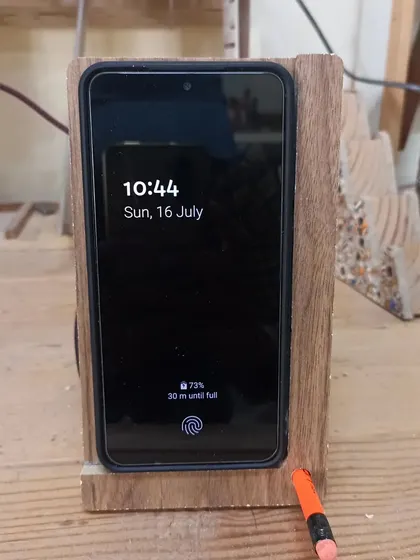 The wireless charging stand in action. The design is minimal and functional, keeping the phone upright and charging without messy cables in the front.