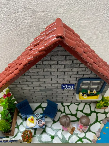 This full view of the 'Vivy Kay' diorama shows the complete scene, including the couple, the miniature furniture, and the little pond with fish.