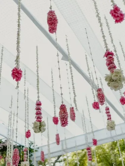 A ceiling of hanging floral strings made from jasmine and pink flowers.