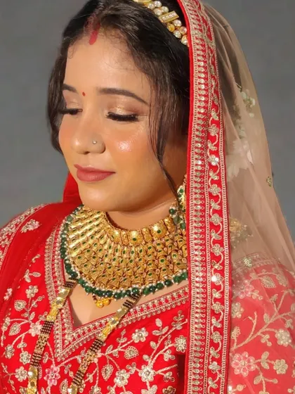 My reception bride Urmila in a classic red lehenga. The makeup features glowing skin and soft gold eyes.