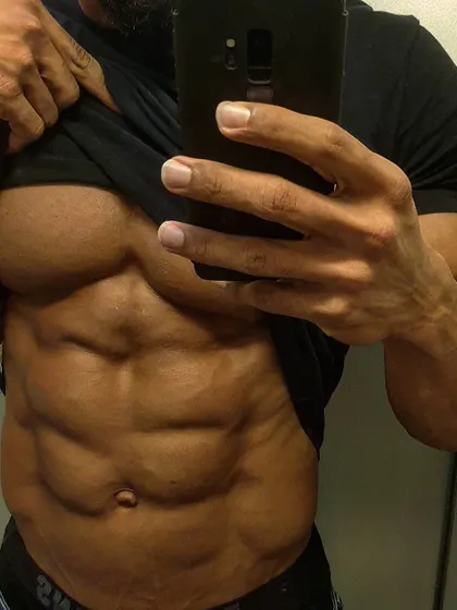 A close-up selfie showcasing a deeply etched six-pack. This is the result of dedicated core work and maintaining a low body fat percentage.