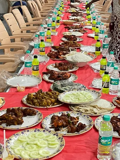 A close-up of the delicious spread at RR Party Hall in Maddur. You can see plates of sliced cucumbers, onions, chicken kebabs, and other starters, all part of our standard Dastarkhwan package.