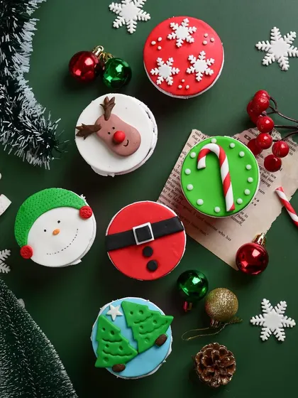 Our hand-decorated Christmas cupcakes are a bite of holiday cheer. This assortment features designs like snowflakes, reindeer, snowmen, and Santa's belt.