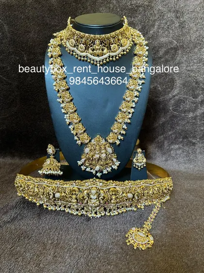 A complete and intricate temple jewellery set with pearl detailing. This rental includes a choker, multi-layered haaram, and a grand vaddanam.