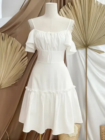 This breezy white summer dress is perfect for warm days. I designed it with a stylish cold-shoulder detail, a ruffled neckline, and a tiered skirt for a light, romantic feel. Like all my pieces, it's made-to-measure for a perfect fit.