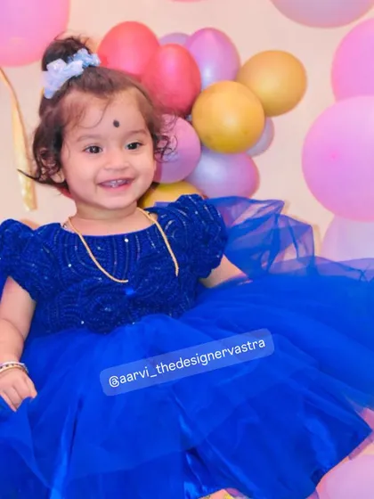 That happy smile says it all. The voluminous tulle skirt of the blue frock is perfect for a birthday celebration.