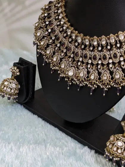 The choker paired with the jhumka earrings, a classic combination.