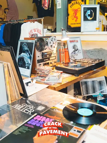 A glimpse of the vibe at 'Crack in the Pavement'. This setup with vinyl records, a reel-to-reel player, and classic hip-hop posters shows our dedication to the culture.