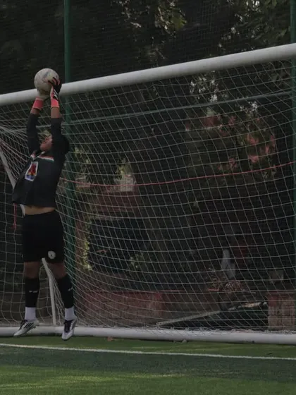 A goalkeeper leaps to make a save, showcasing his agility and reach. Our keepers are trained to be the last line of defense and a commanding presence.