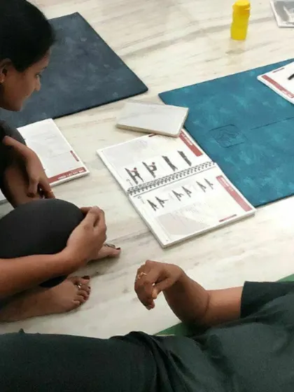 Students collaborating and reviewing the exercise manual during a training session. The program includes comprehensive printed materials with clear illustrations and instructions for every exercise.