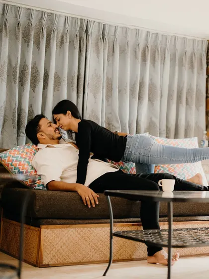 A playful and loving moment on the couch. This candid shot captures the pure fun and affection that is central to their relationship.