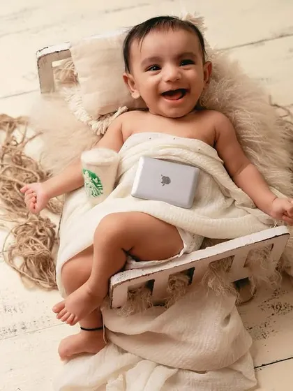 The future CEO. This fun and creative newborn setup with a tiny laptop and coffee cup is a playful take on modern life.
